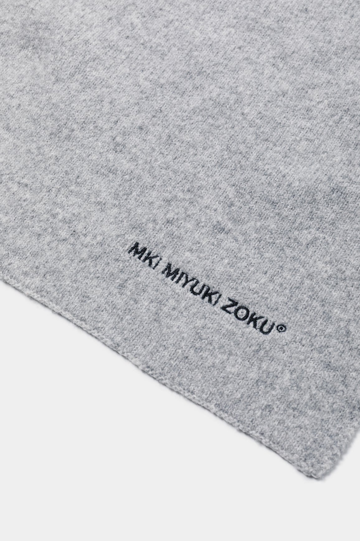 Close-up of the black MKI MIYUKI ZOKU logo embroidered on the Ash double knit wool blend