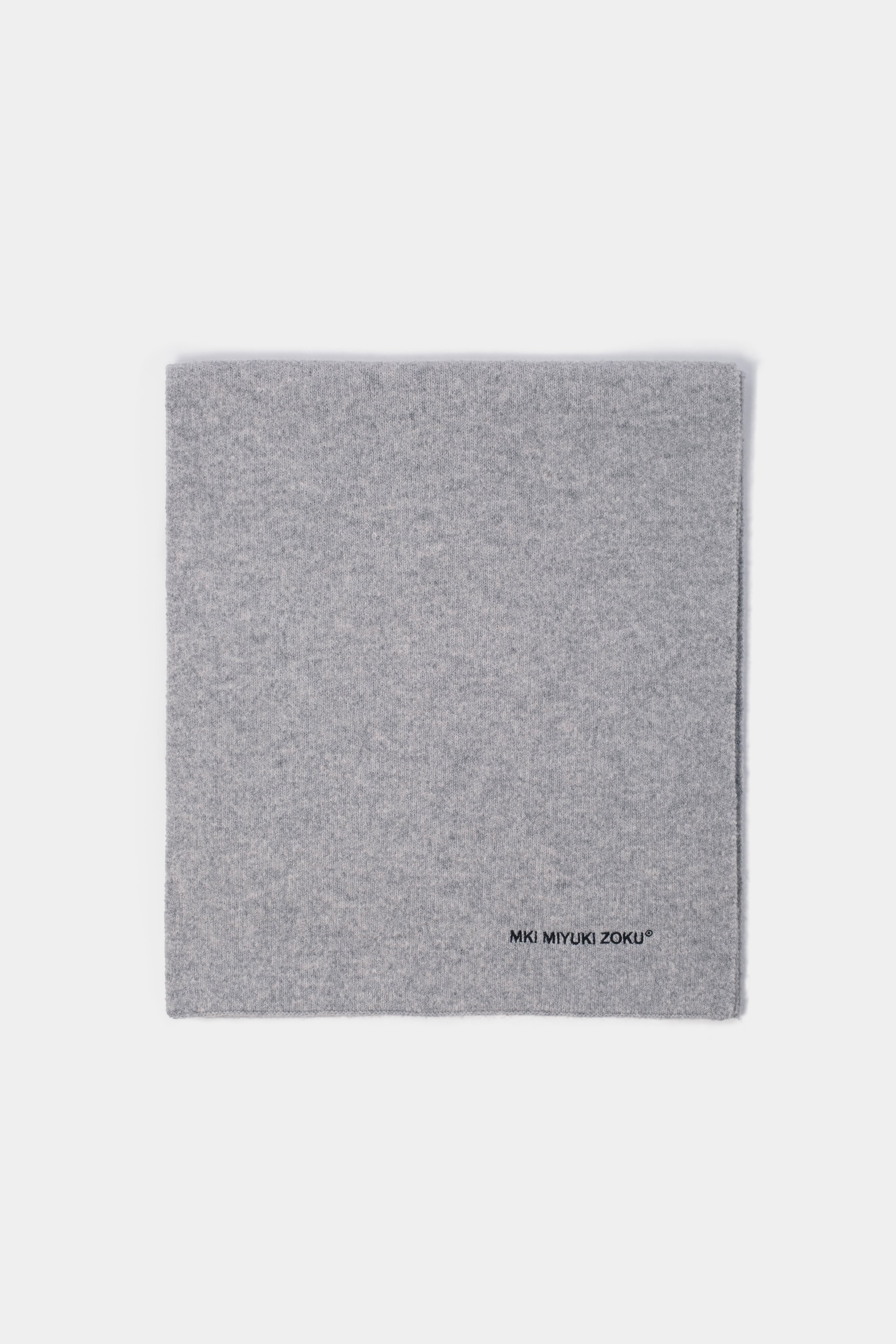Folded flat lay of the Ash double knit scarf showing the black logo embroidery at the corner