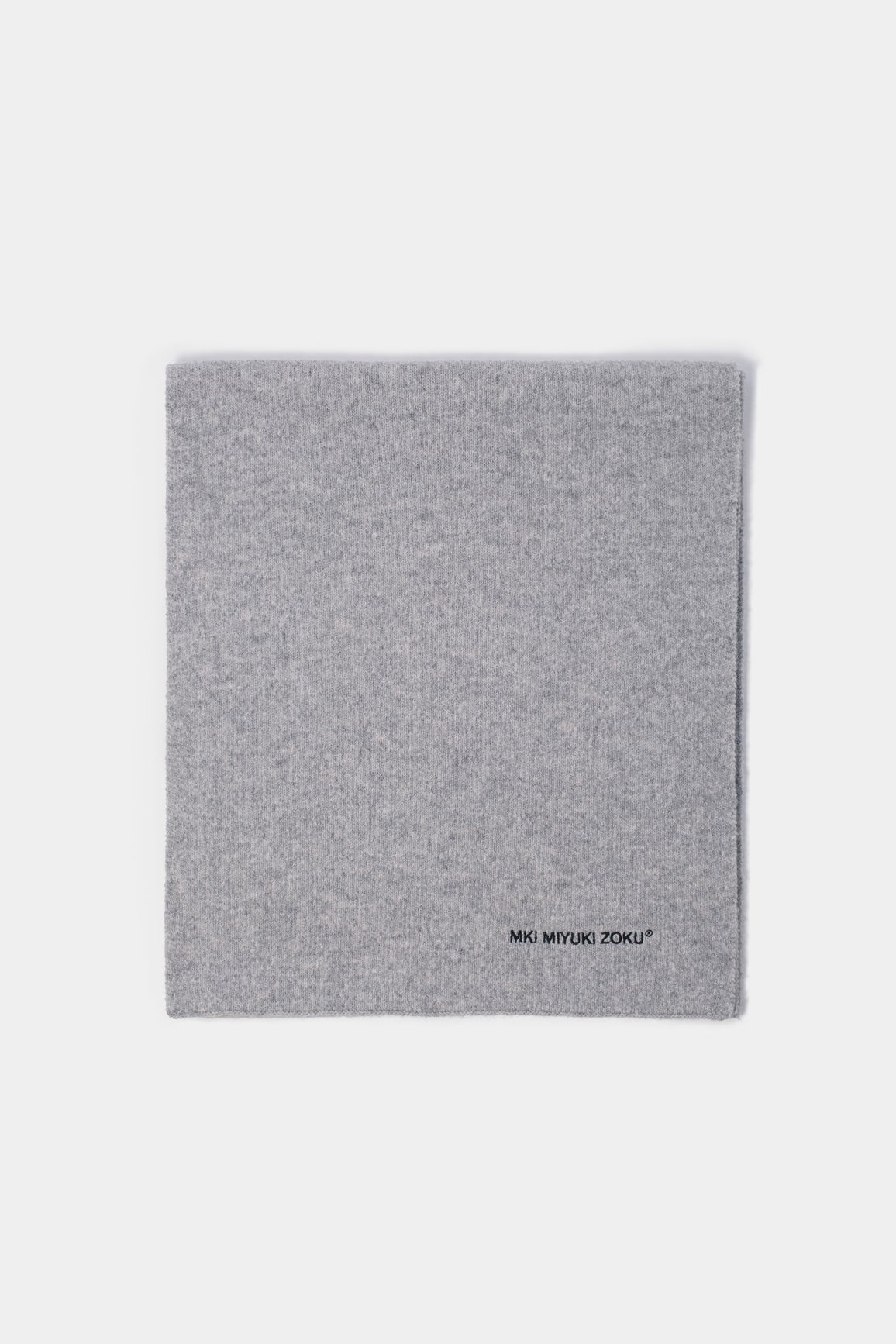 Folded flat lay of the Ash double knit scarf showing the black logo embroidery at the corner