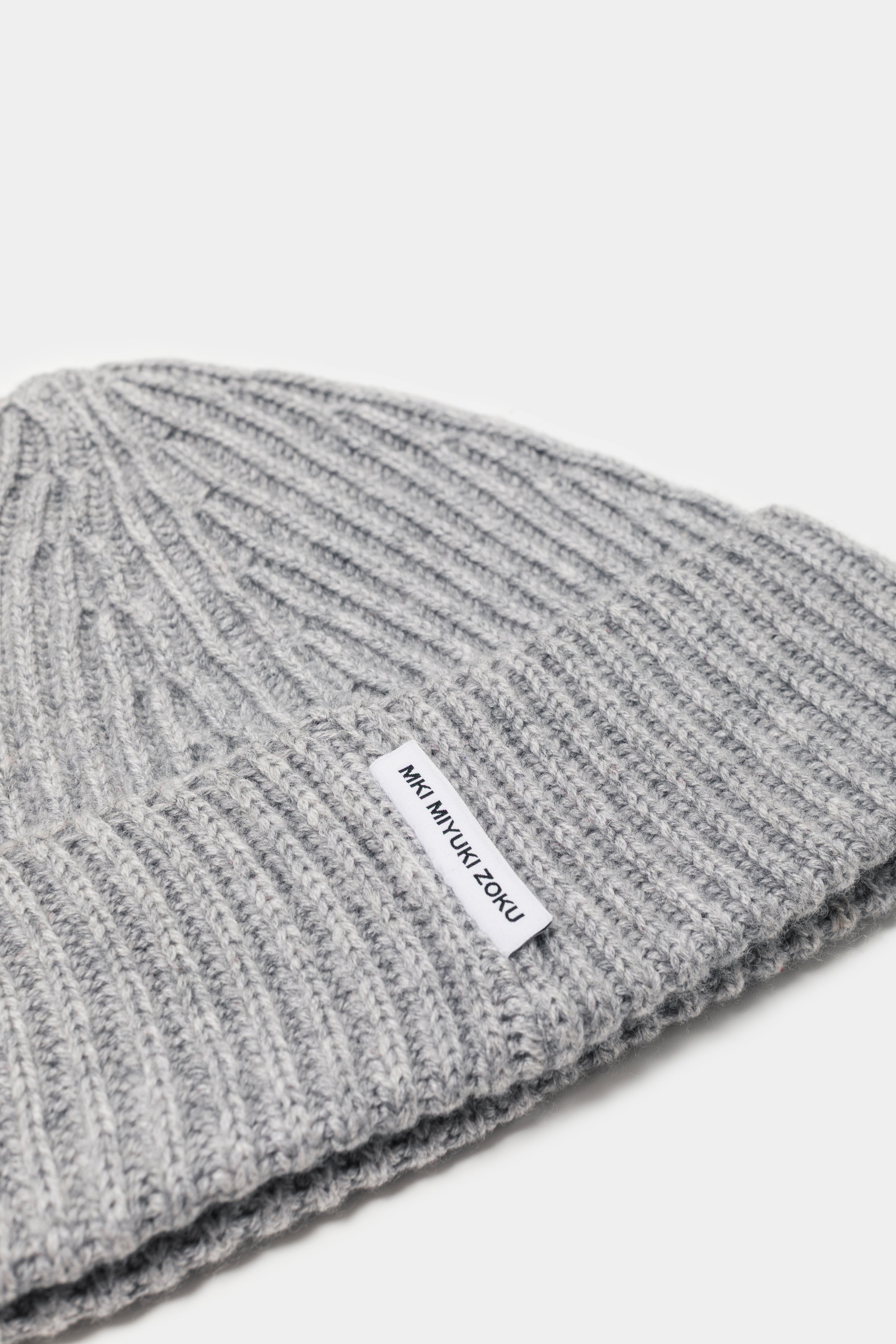 Close-up of the woven MKI MIYUKI ZOKU tag and heavy rib knit on the Light Grey cashmere beanie