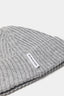 Close-up of the woven MKI MIYUKI ZOKU tag and heavy rib knit on the Light Grey cashmere beanie