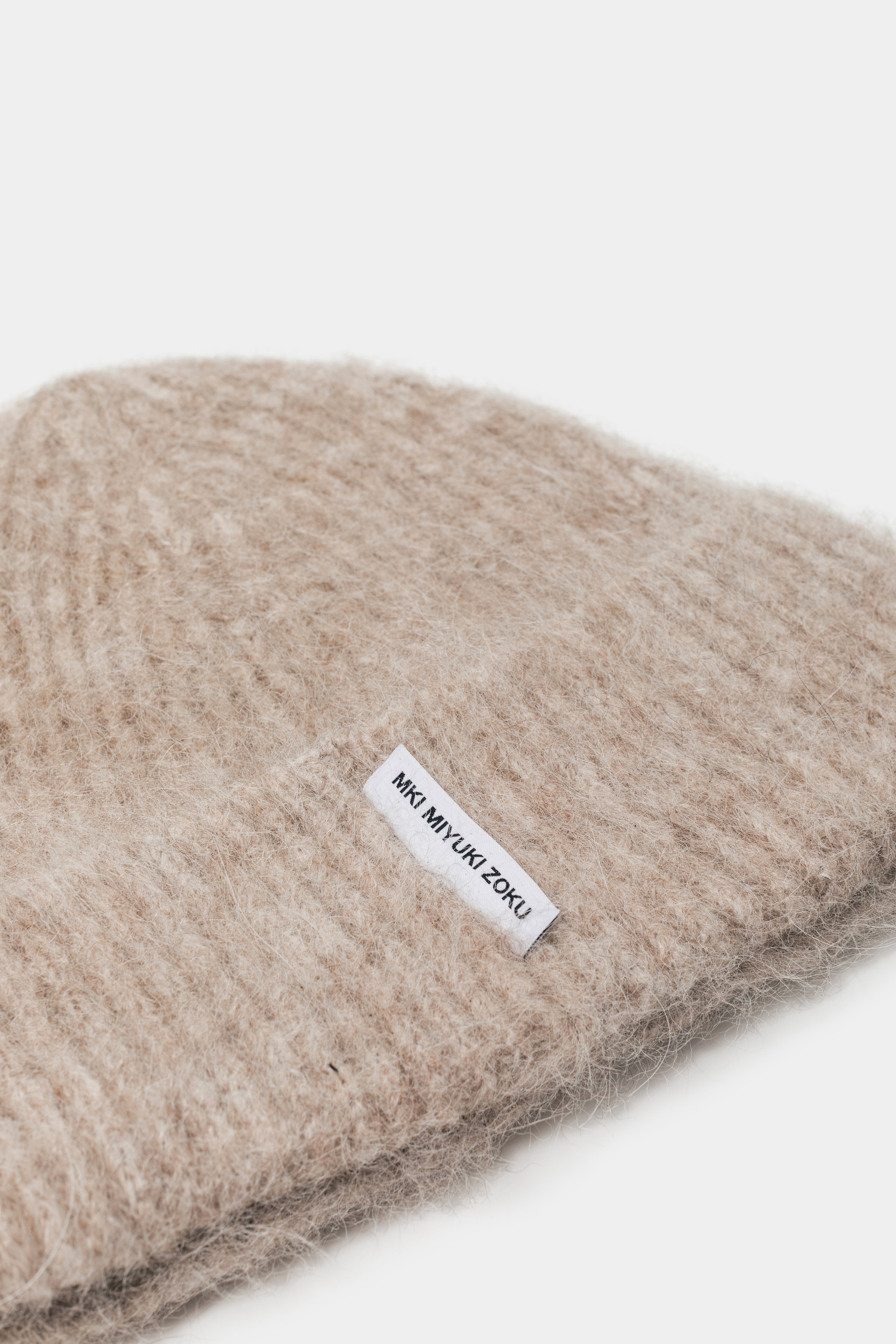 Close-up of the woven MKI MIYUKI ZOKU tag and fuzzy alpaca knit on the Oatmeal beanie