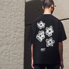 Person wearing a black t-shirt with a white floral graphic on the back