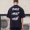 Person wearing a black t-shirt with white graphic logos on the back
