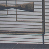 Metal bowtie sculpture mounted on a slatted wall panel