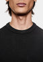 Close-up of the ribbed crew neckline on the black slub cotton jersey