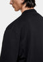 Close-up of the dropped shoulder seam and textured slub jersey on the black T-shirt