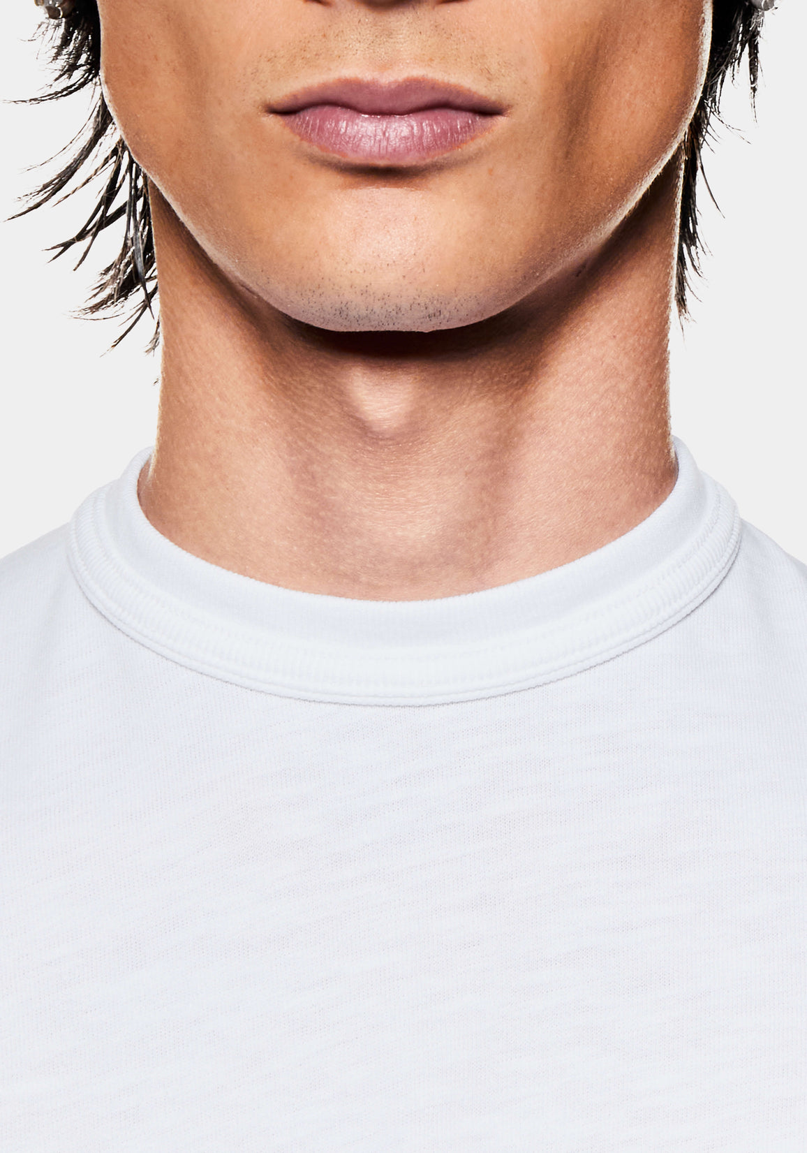 Close-up of the ribbed crew neckline on the white slub cotton jersey