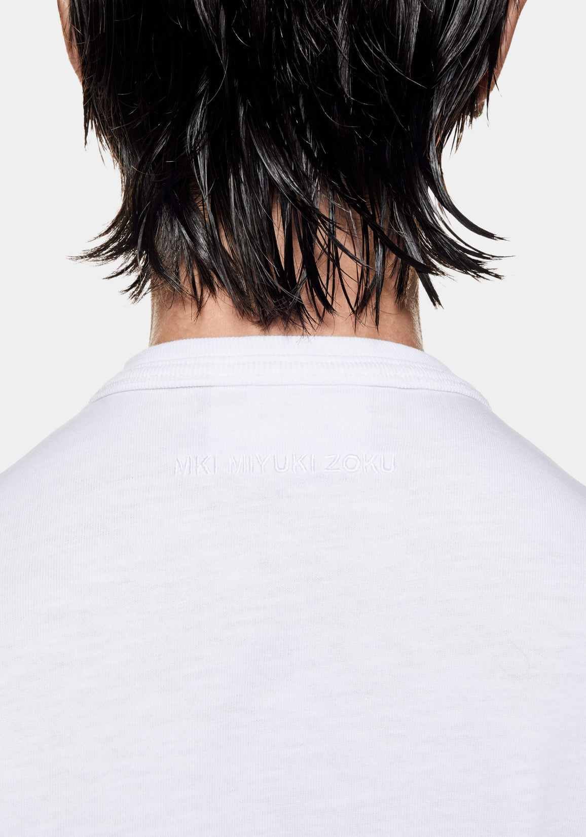 Close-up of the tonal MKI MIYUKI ZOKU logo embroidered below the back neck