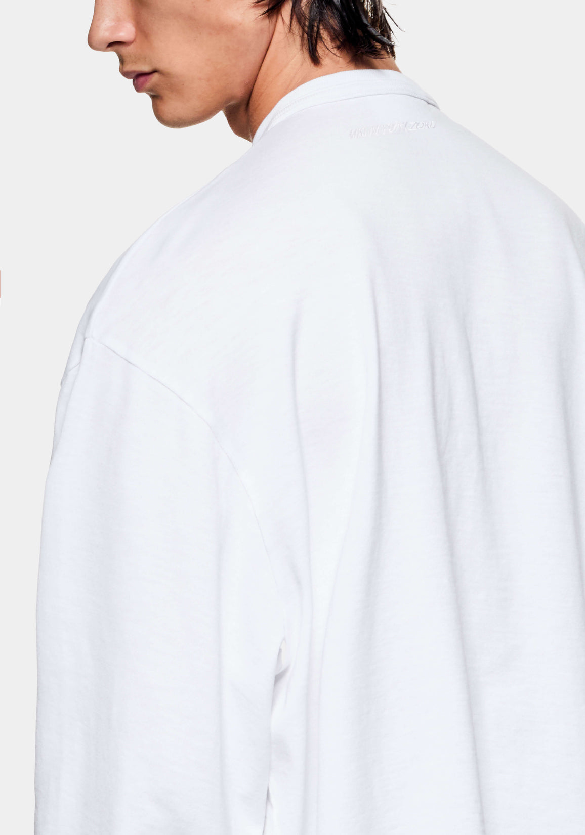 Close-up of the dropped shoulder seam and textured slub jersey on the white T-shirt