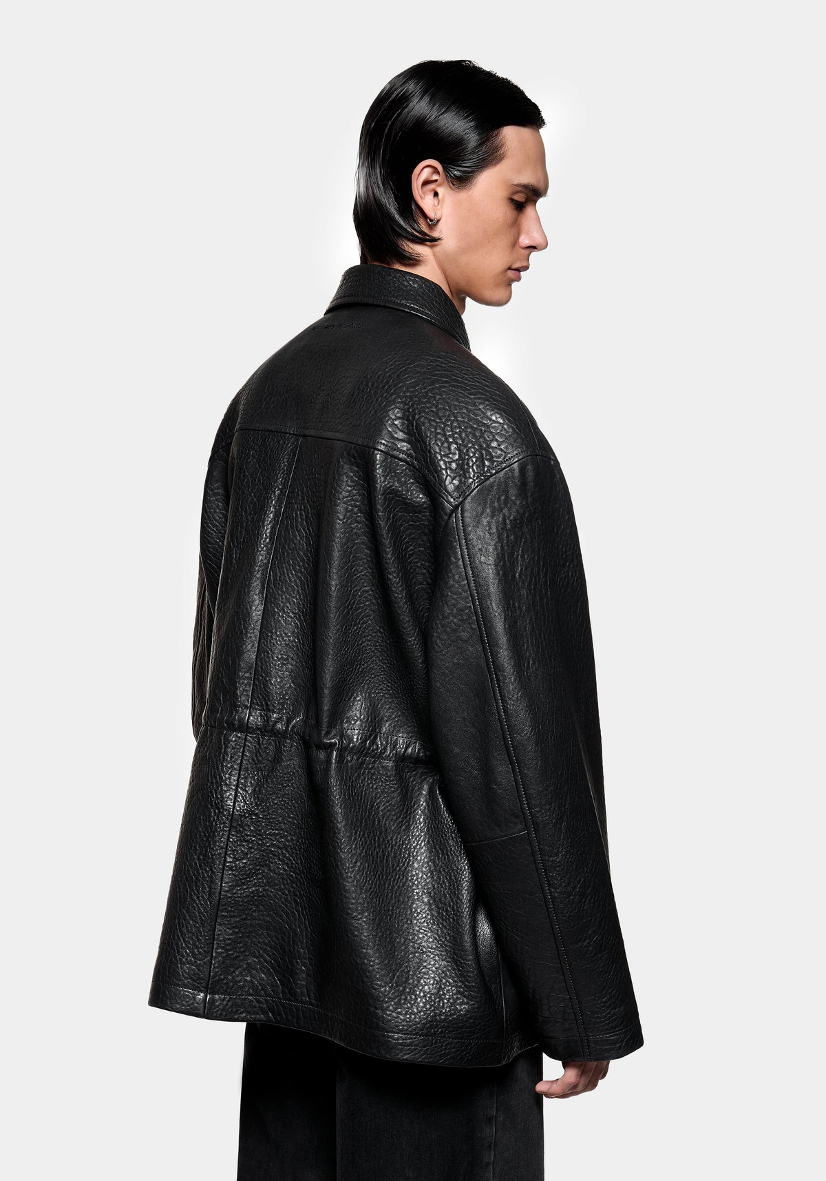 Side view showing the elastic waist adjustment on the Bubble Leather Field Jacket in Black