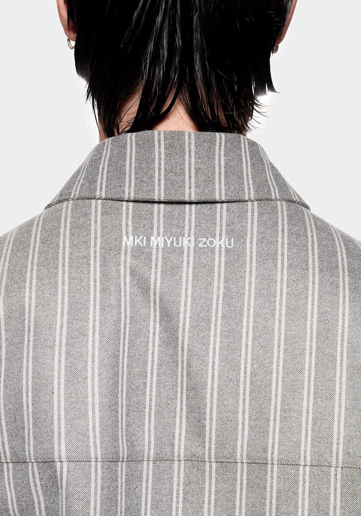Close-up of the MKI MIYUKI ZOKU logo embroidery at the collar on the Box Dress Shirt in Grey Stripe