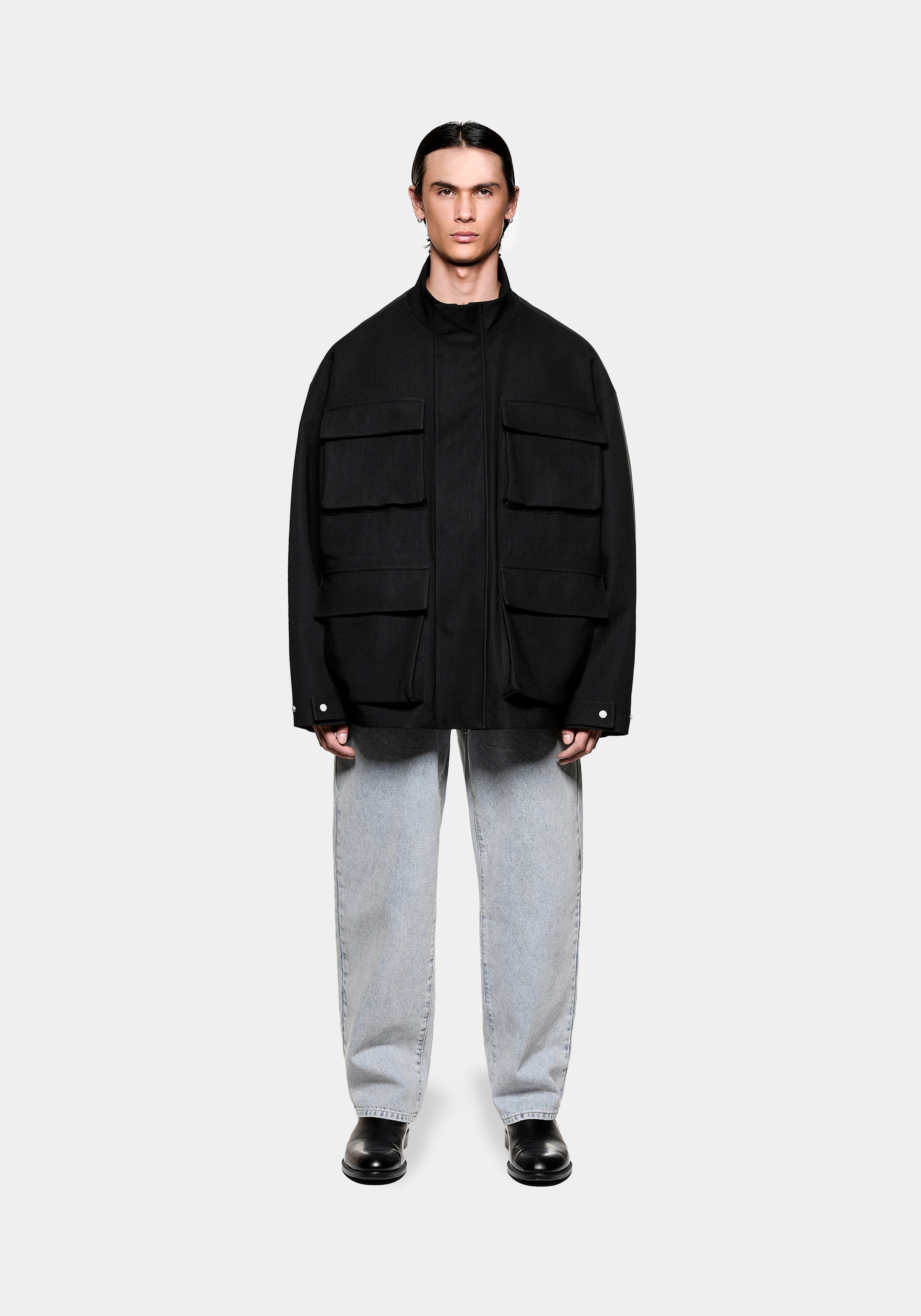 MKI MIYUKI ZOKU Tech Canvas Field Jacket in Black, front view showing the four 3D flap pockets, styled with bleach wash jeans
