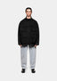 MKI MIYUKI ZOKU Tech Canvas Field Jacket in Black, front view showing the four 3D flap pockets, styled with bleach wash jeans
