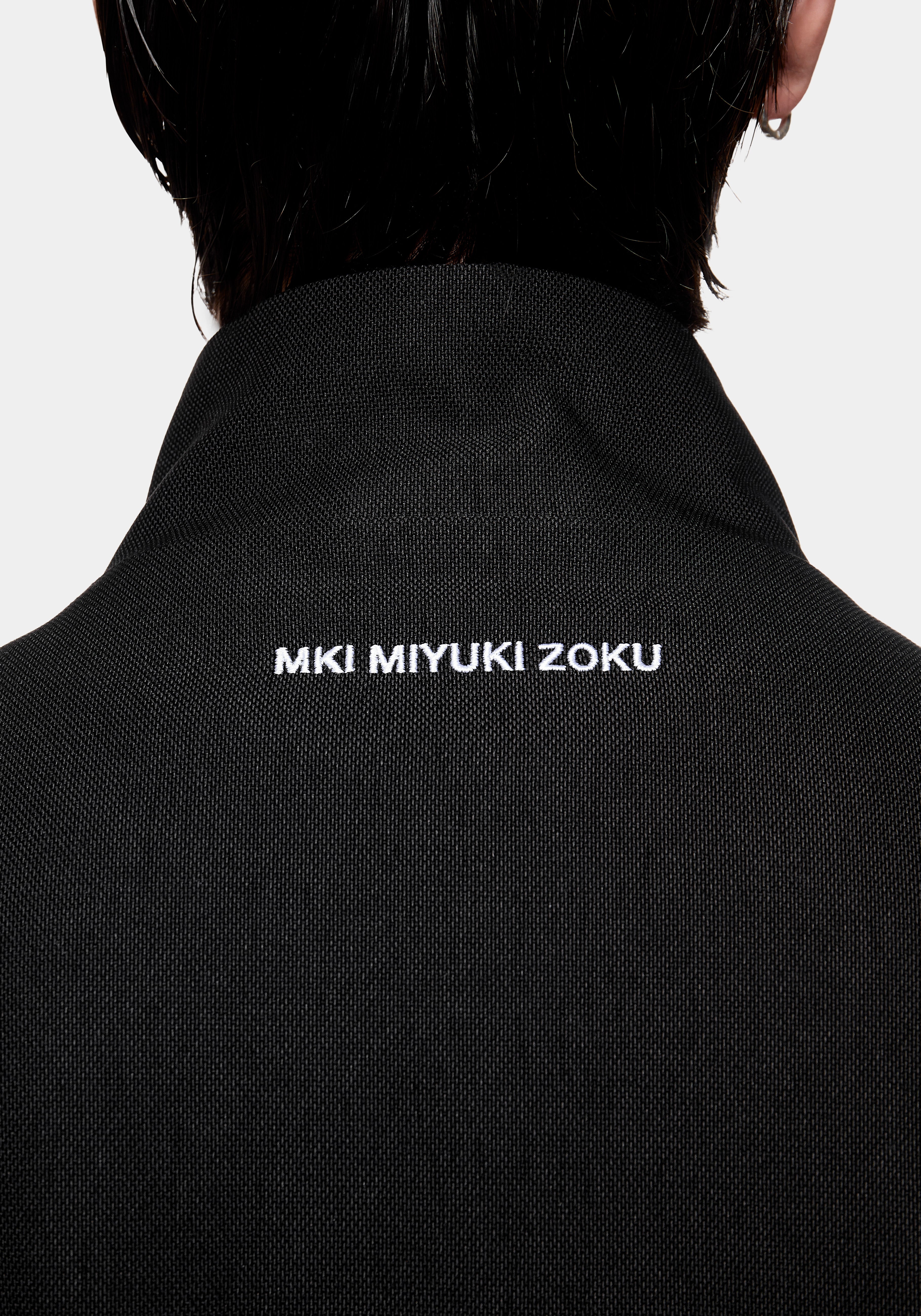 Close-up of the MKI MIYUKI ZOKU logo embroidered at the back neck