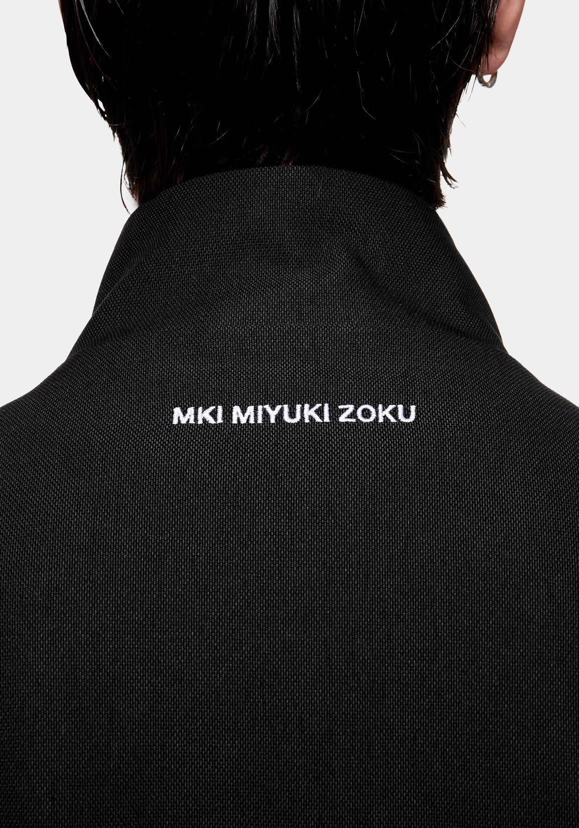 Close-up of the MKI MIYUKI ZOKU logo embroidered at the back neck