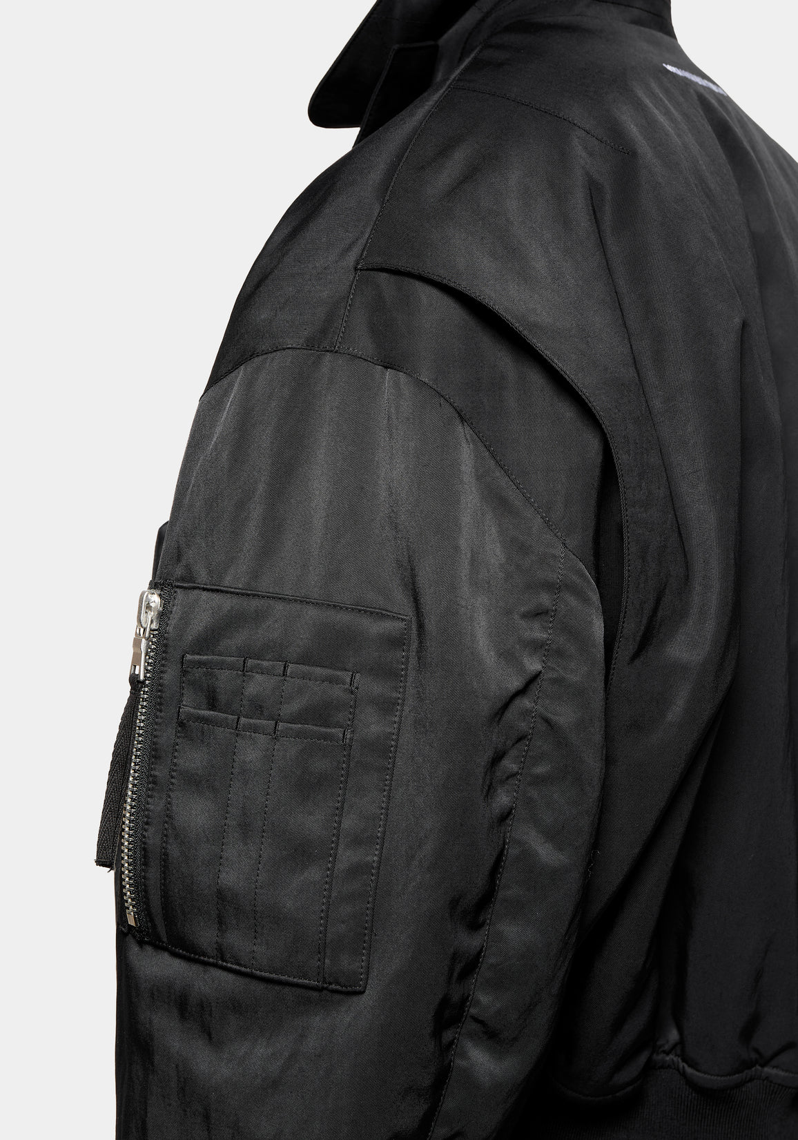 Close-up of the sleeve pen pocket and zip detail