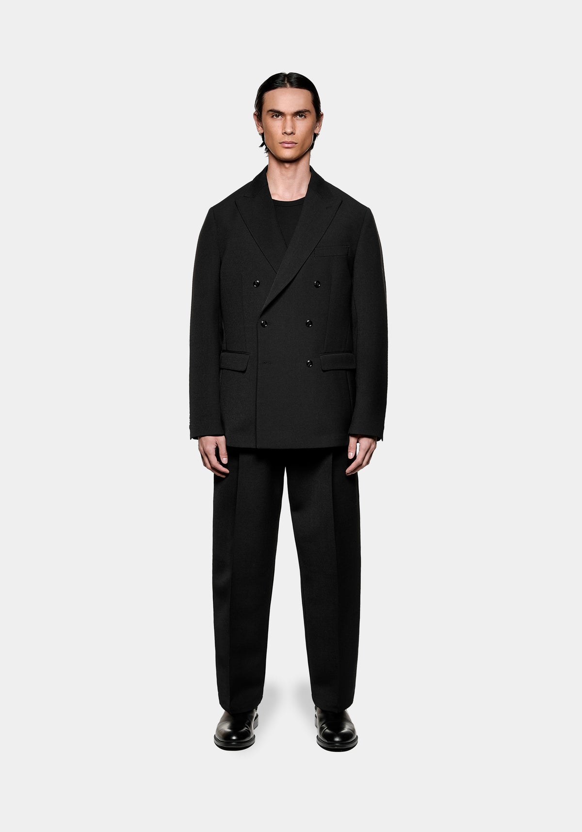 Man wearing a black double-breasted blazer and matching trousers