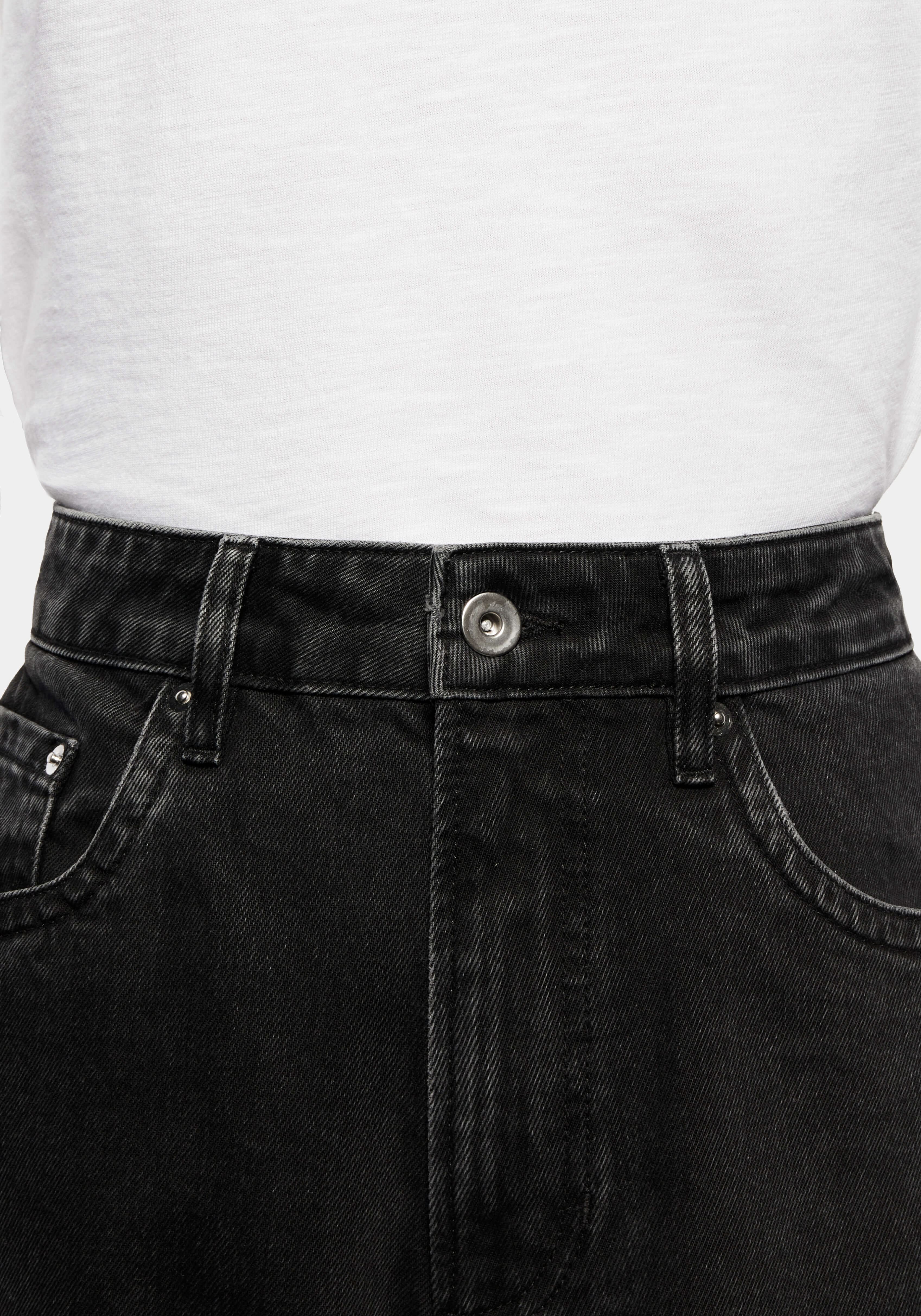 Close-up of the waistband, donut button and five-pocket front of the Black Wash jeans