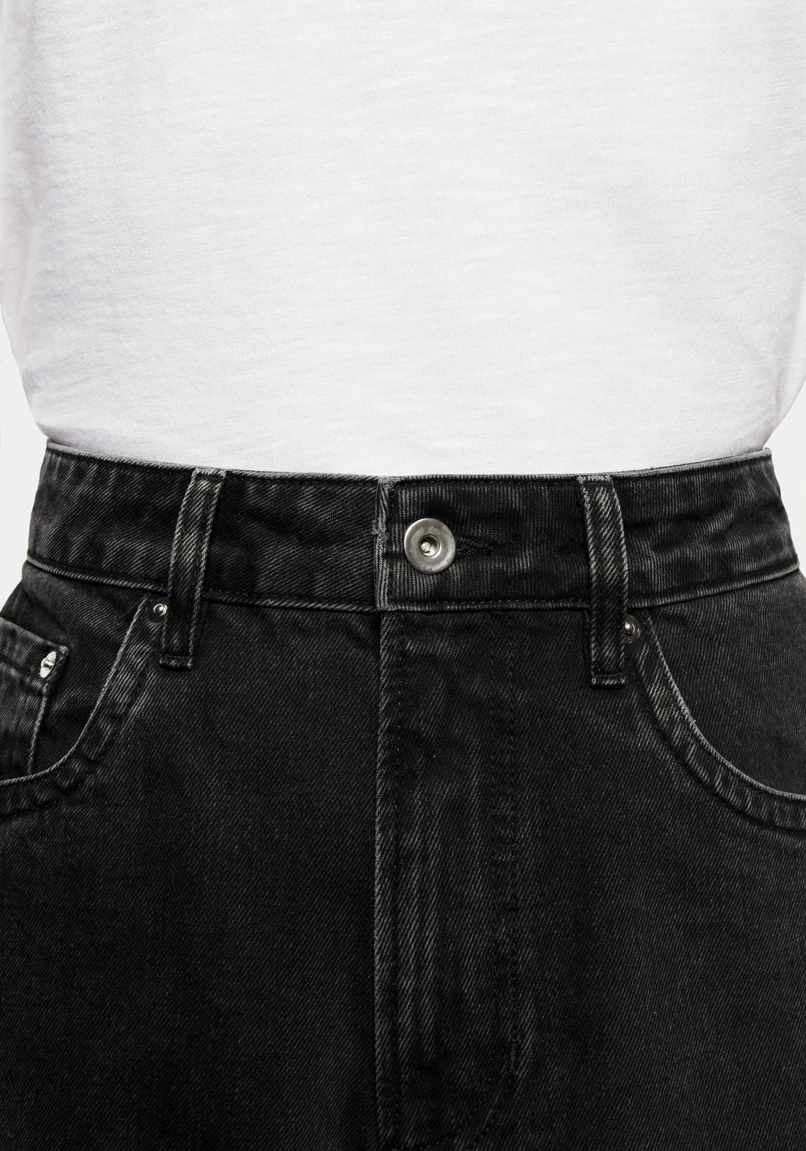 Close-up of the waistband, donut button and five-pocket front of the Black Wash jeans
