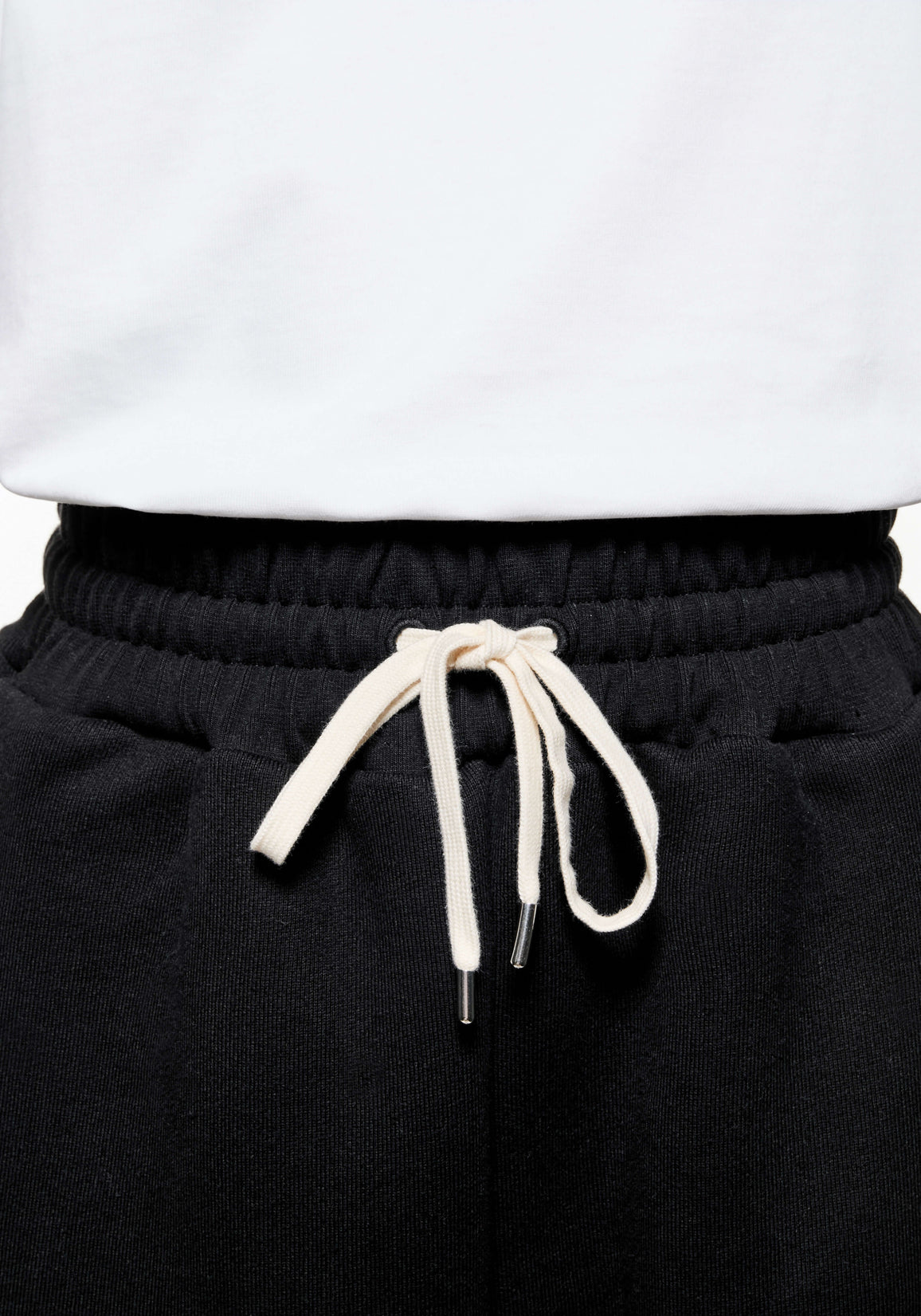 Close-up of the elasticated waistband and white metal-tipped drawstrings on the Black Superweight Joggers