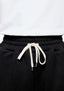 Close-up of the elasticated waistband and white metal-tipped drawstrings on the Black Superweight Joggers