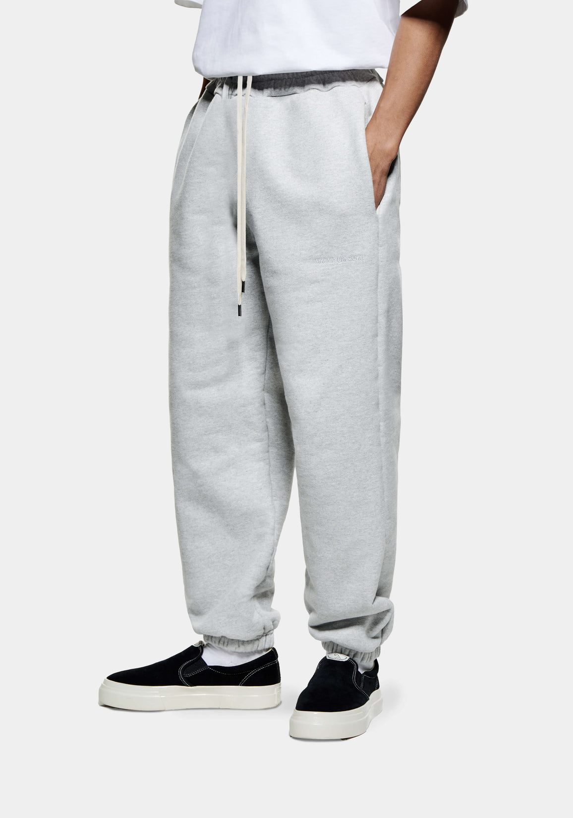 Front three-quarter view of the Grey Superweight Joggers showing the heavy drape and cuffed hems over black slip ons
