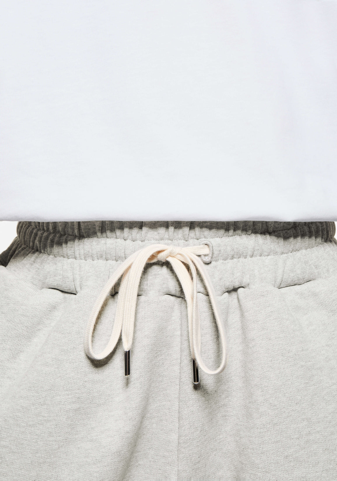 Close-up of the elasticated waistband and cream metal-tipped drawstrings on the Oatmeal joggers