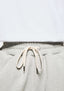 Close-up of the elasticated waistband and cream metal-tipped drawstrings on the Oatmeal joggers