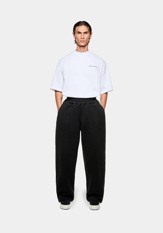 Full view of the MKI Superweight men's wide leg joggers in black cotton jersey with open hems in a loose fit