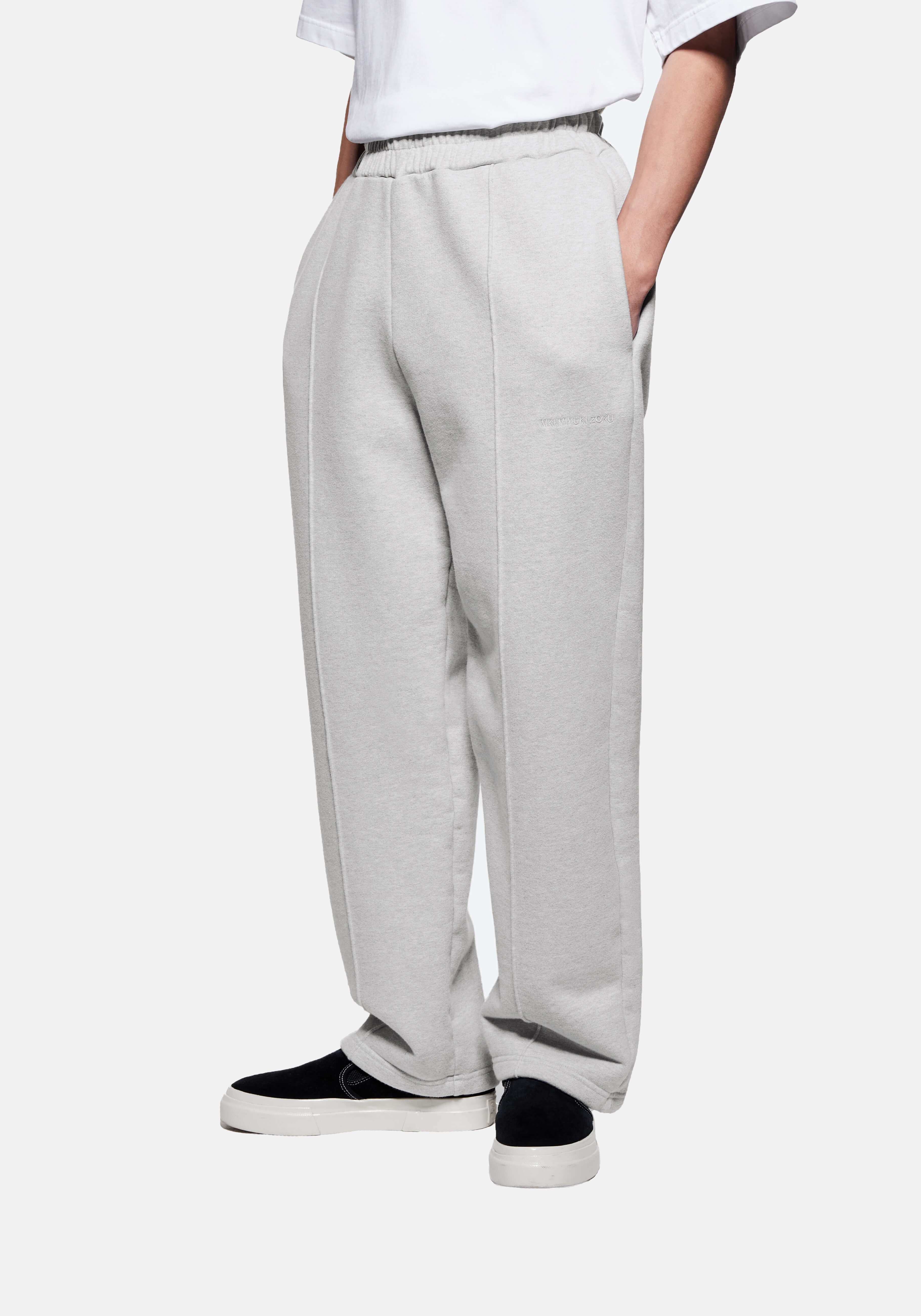 Front three-quarter view of the Grey Wide Leg Joggers showing the sewn-in pleat and heavy drape