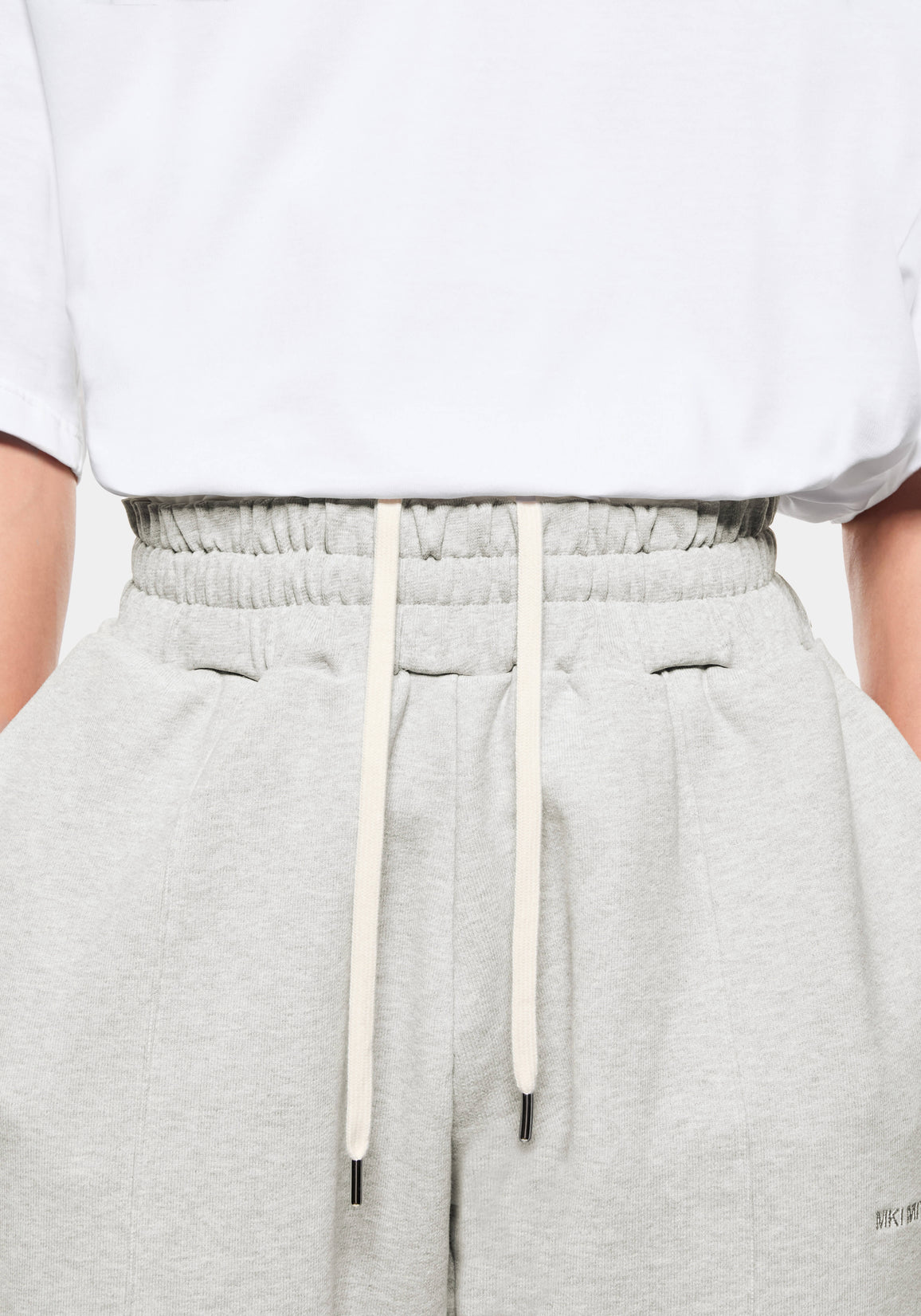 Close-up of the elasticated waistband on the Oatmeal Wide Leg Joggers, with the internal cream drawstrings pulled out to show them