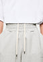 Close-up of the elasticated waistband on the Oatmeal Wide Leg Joggers, with the internal cream drawstrings pulled out to show them