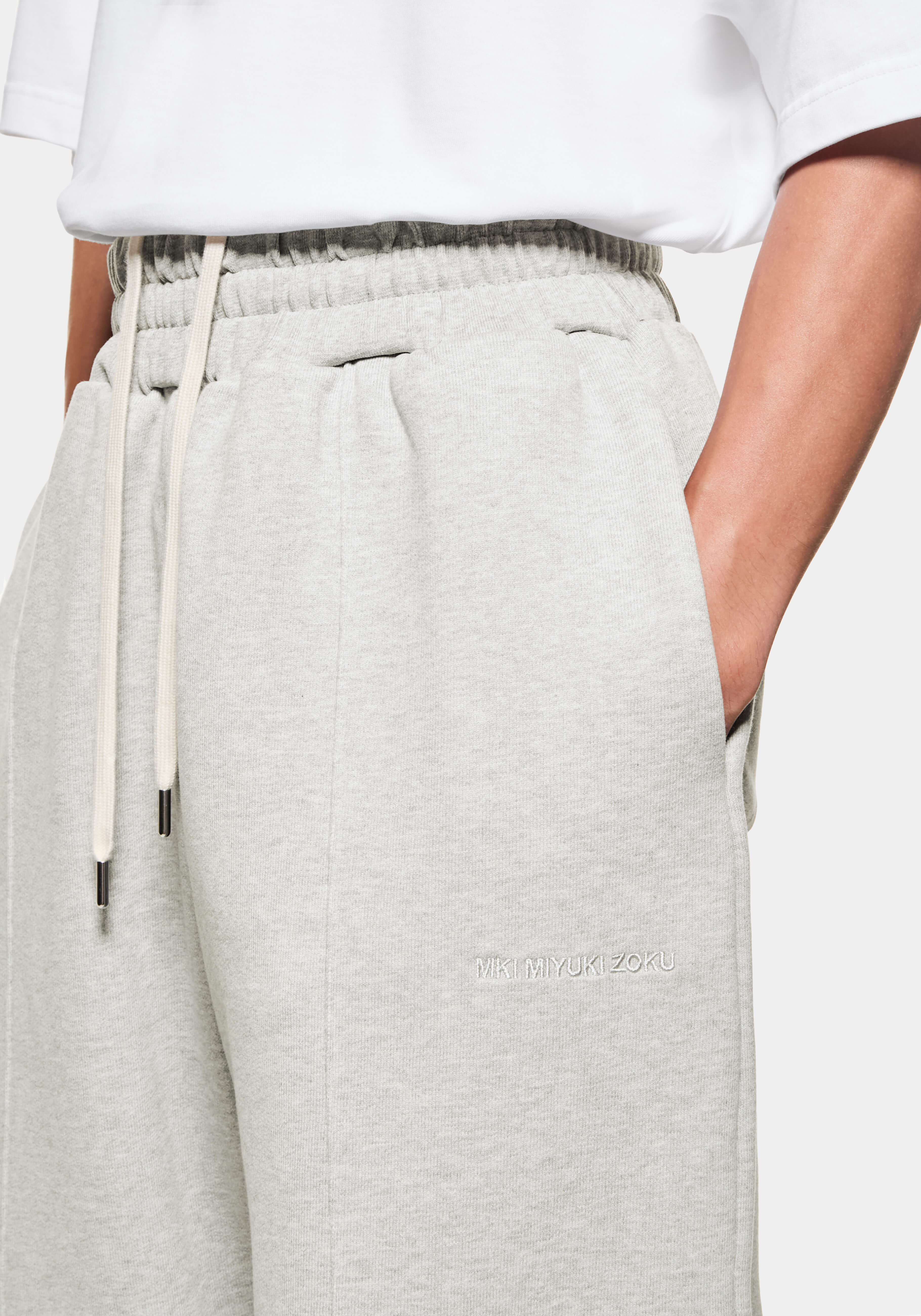 Close-up of the side entry pocket, front pleat and tonal logo embroidery on the Oatmeal joggers