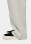 Close-up of the open hem of the Oatmeal joggers falling over black slip ons