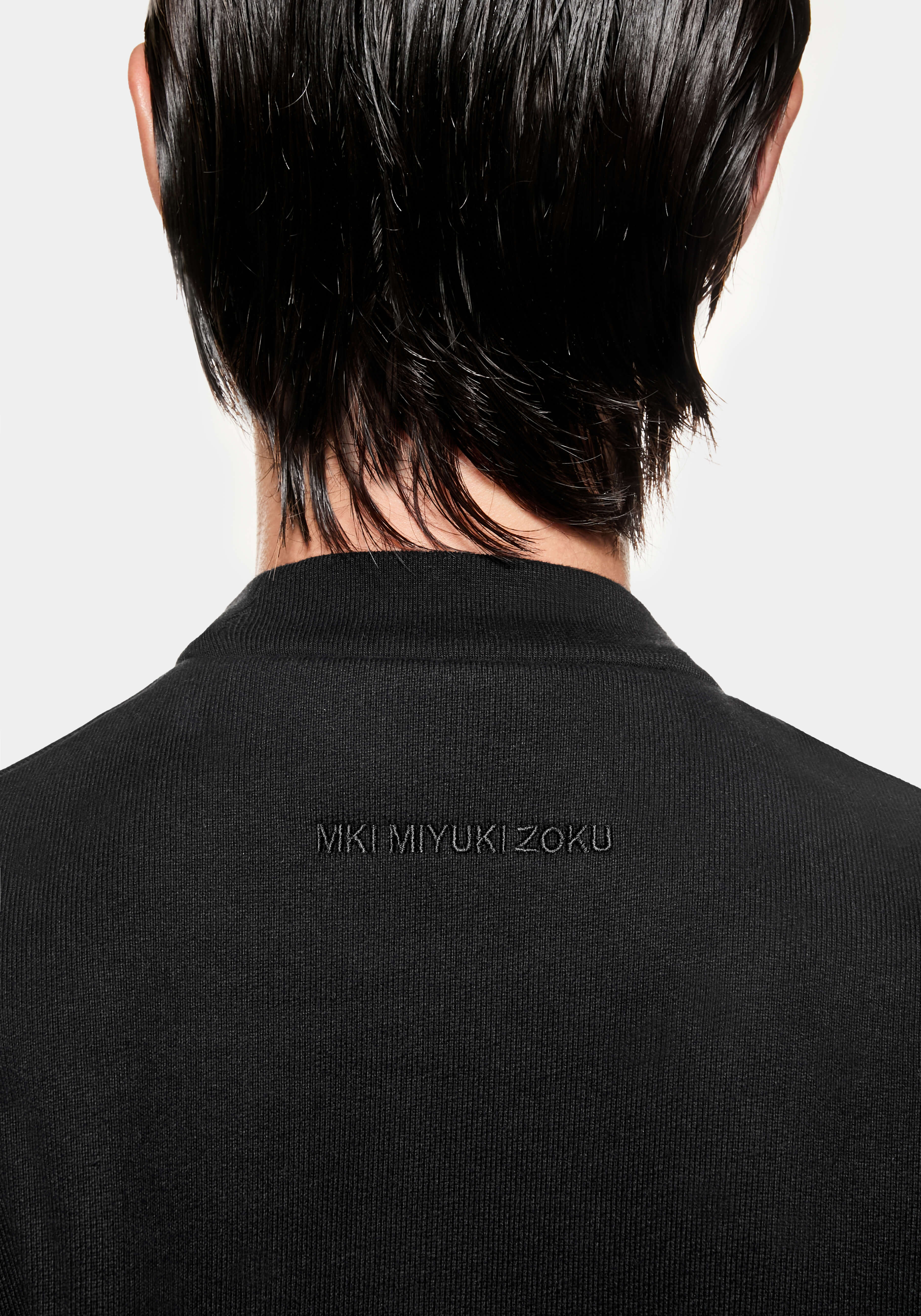 Close-up of the tonal black MKI MIYUKI ZOKU logo embroidered below the back neck