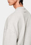 Close-up of the dropped shoulder seam and tonal back-neck embroidery on the oatmeal crewneck