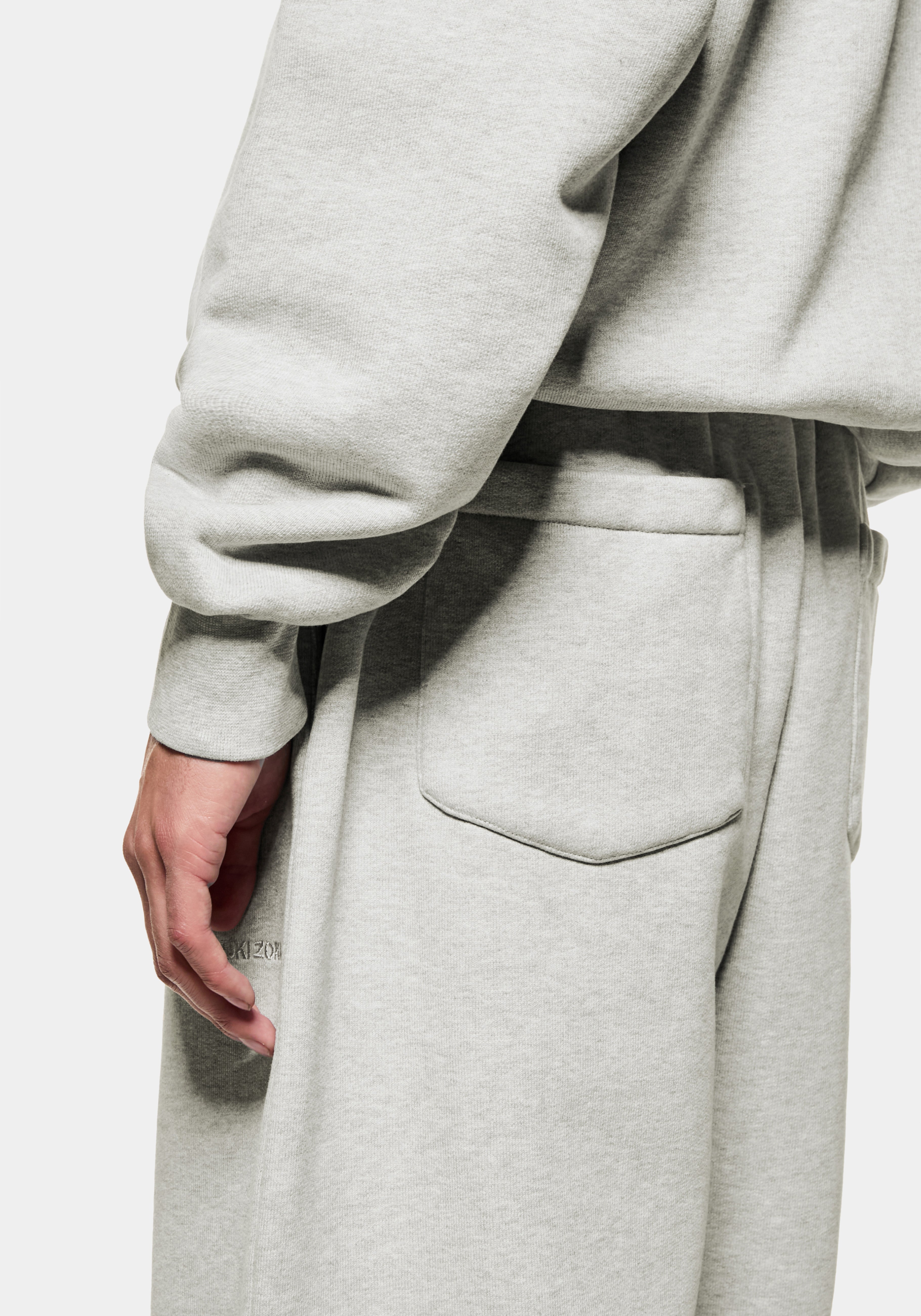 Close-up of the ribbed cuff and hem of the oatmeal crewneck over the matching joggers