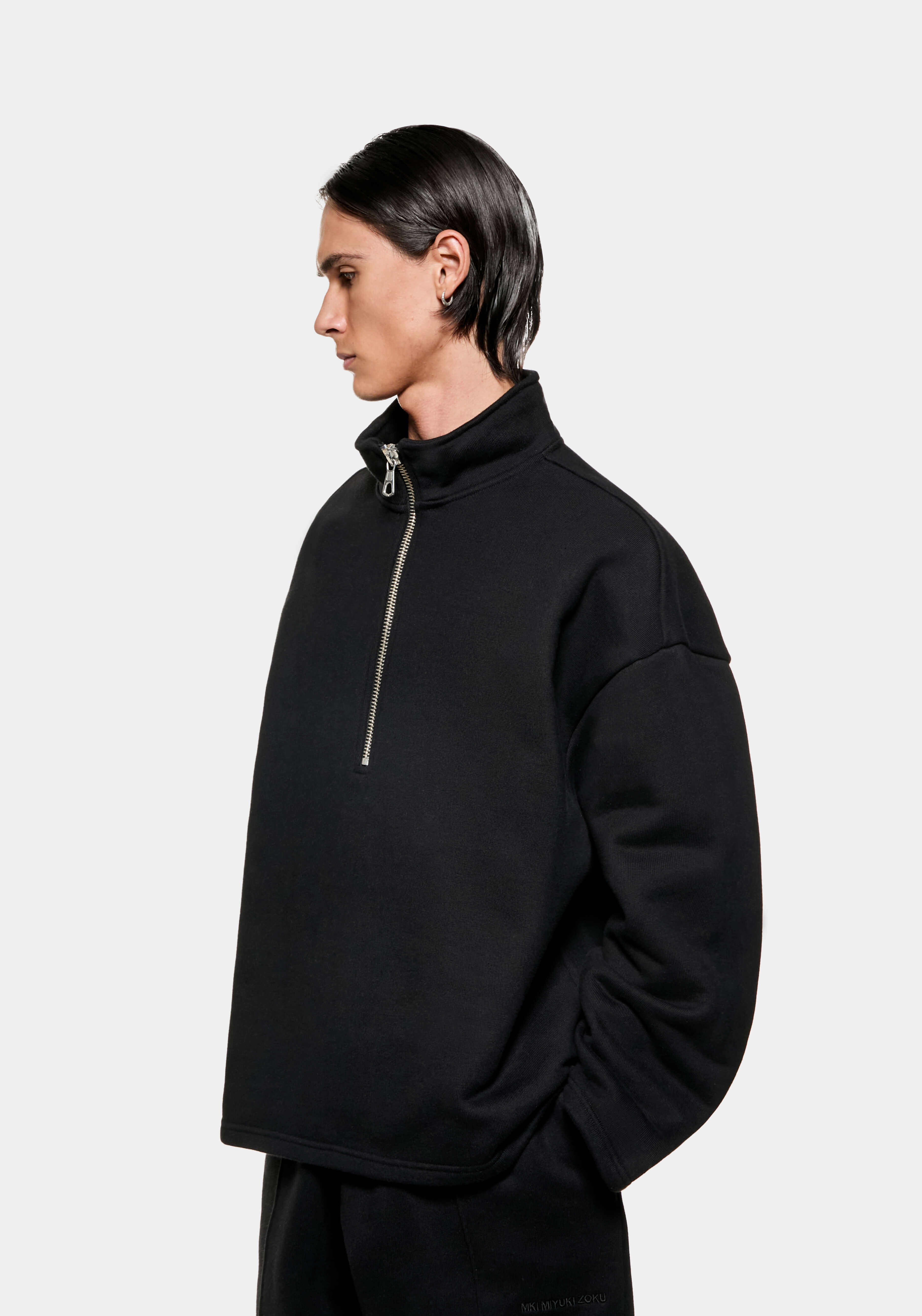 Three-quarter view of the Black Superweight Quarter Zip showing the dropped shoulders and open hem