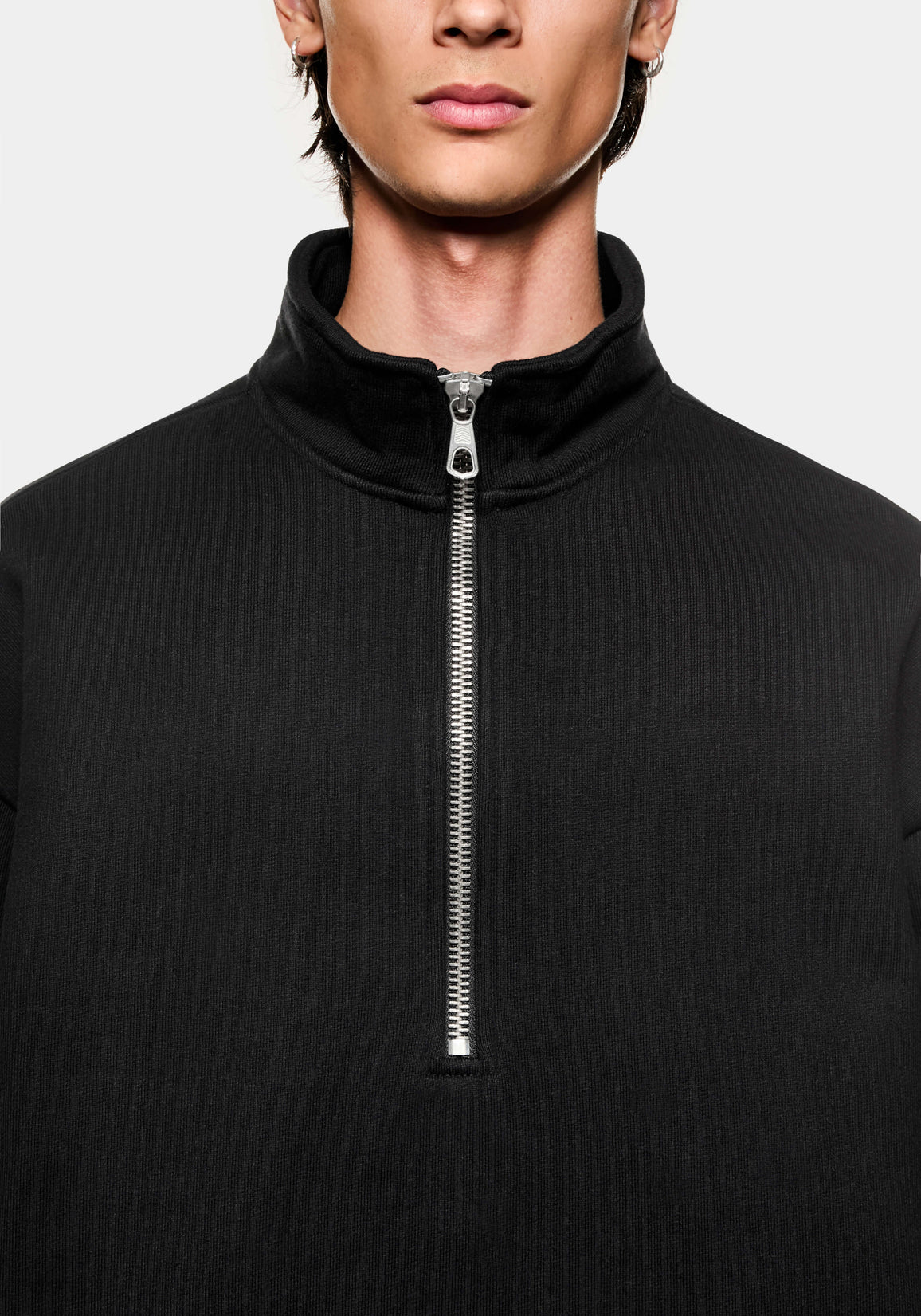 Close-up of the funnel neck and #8 silver metal quarter zip on the Black sweatshirt