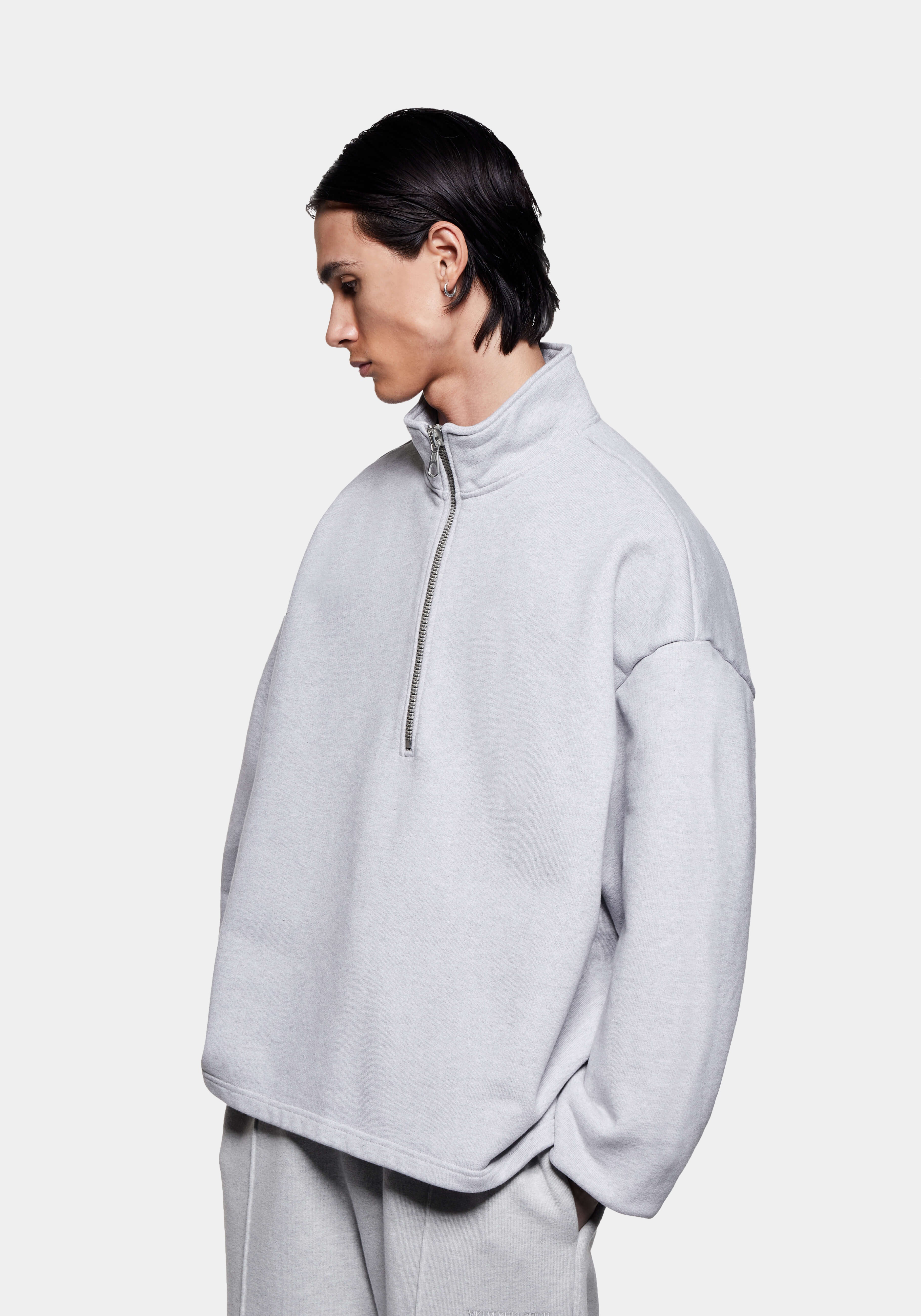 Three-quarter view of the Grey Superweight Quarter Zip showing the dropped shoulders and open hem