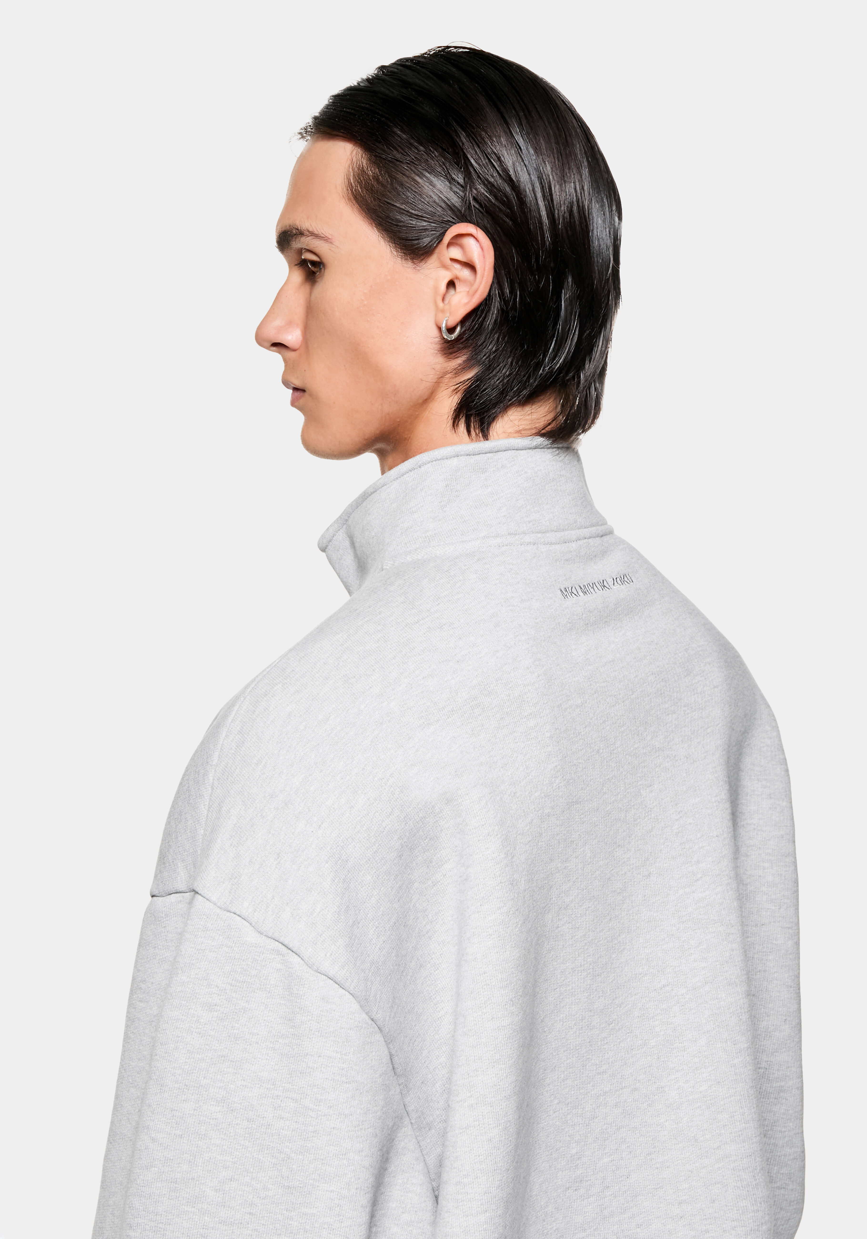 Side profile of the Grey Quarter Zip showing the funnel neck and tonal logo below the collar