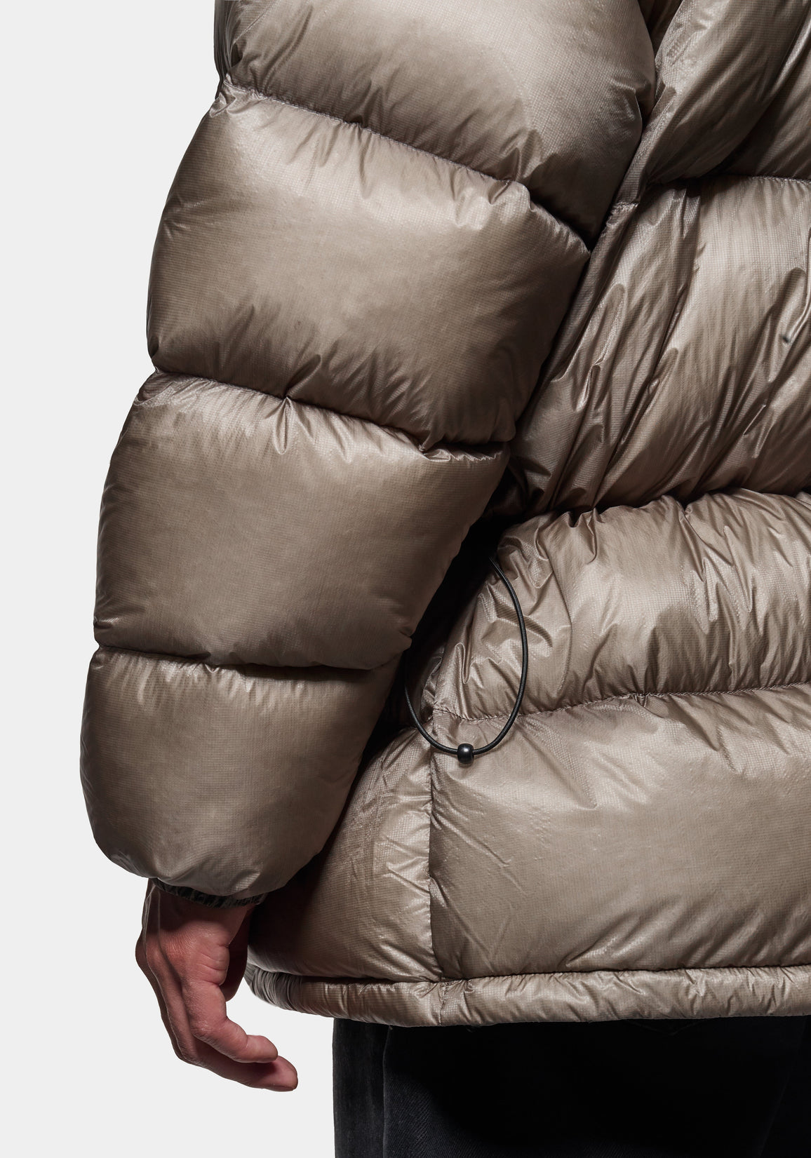 Close-up of the MKI MIYUKI ZOKU brand label on the Apex Down Parka in Moss