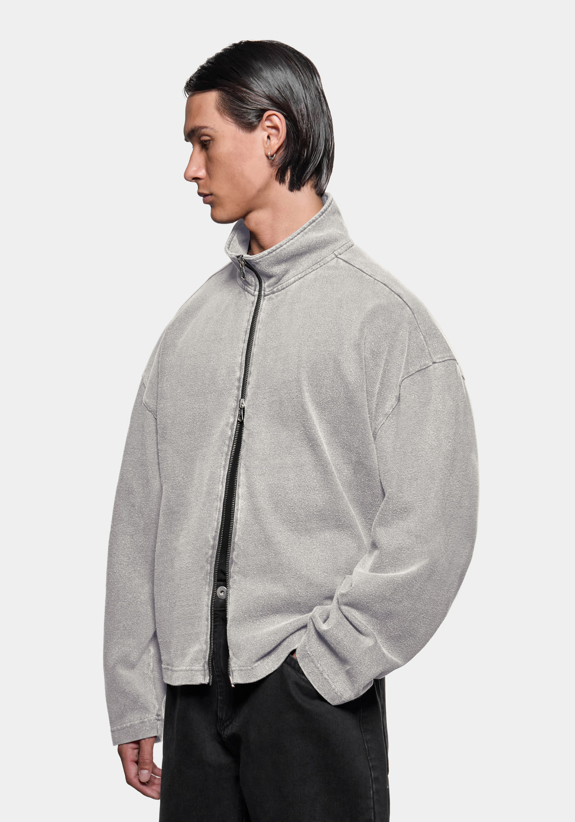 Front view of the track jacket showing the zip funnel neck, styled with black trousers
