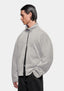 Front view of the track jacket showing the zip funnel neck, styled with black trousers