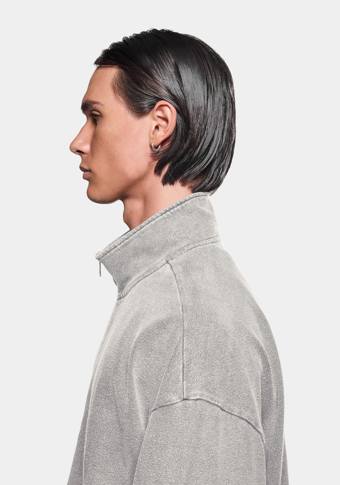 Profile view of the track jacket showing the zip funnel neck