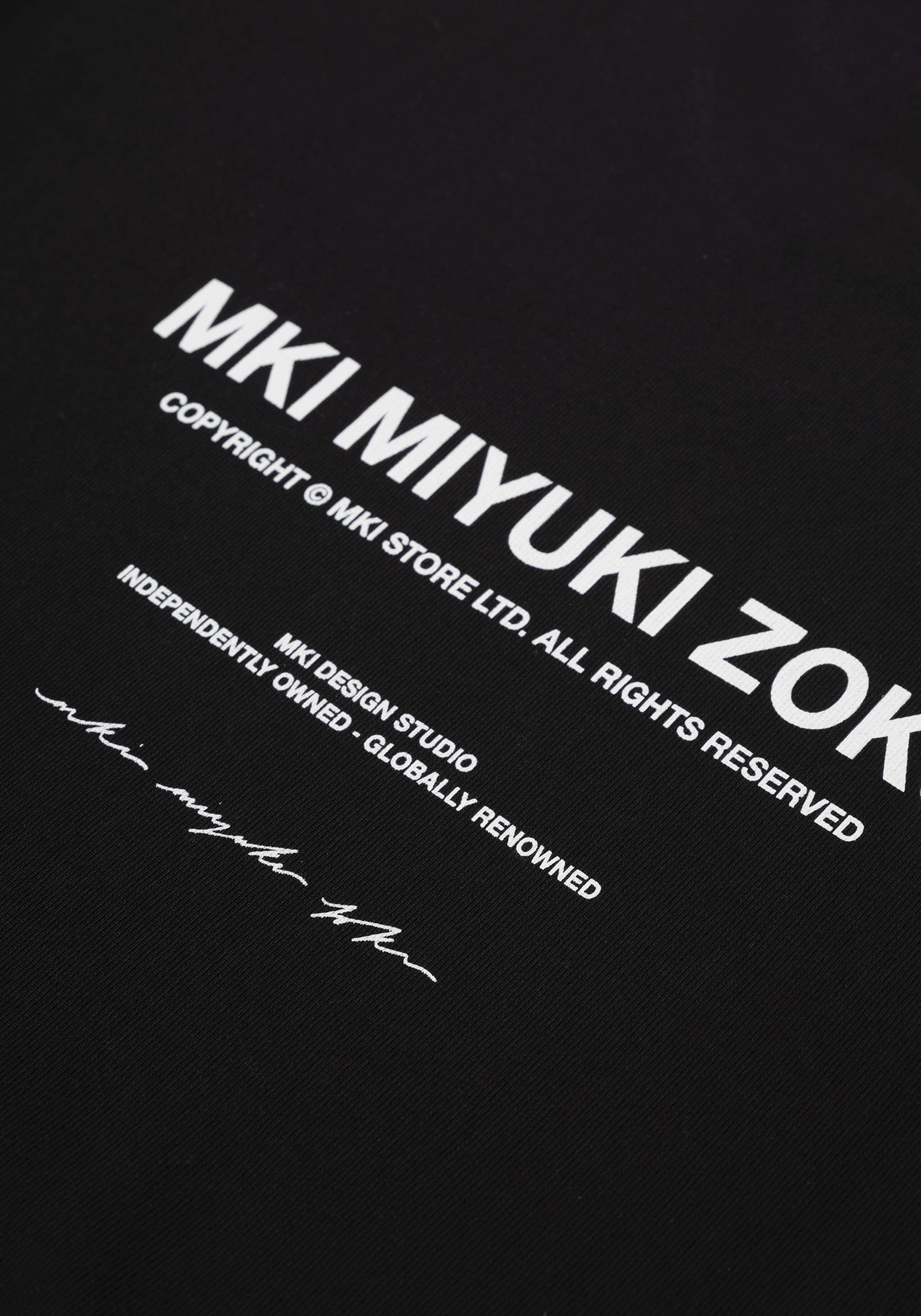 Flat close-up of the printed rear branding on the Design Studio Crewneck in Black