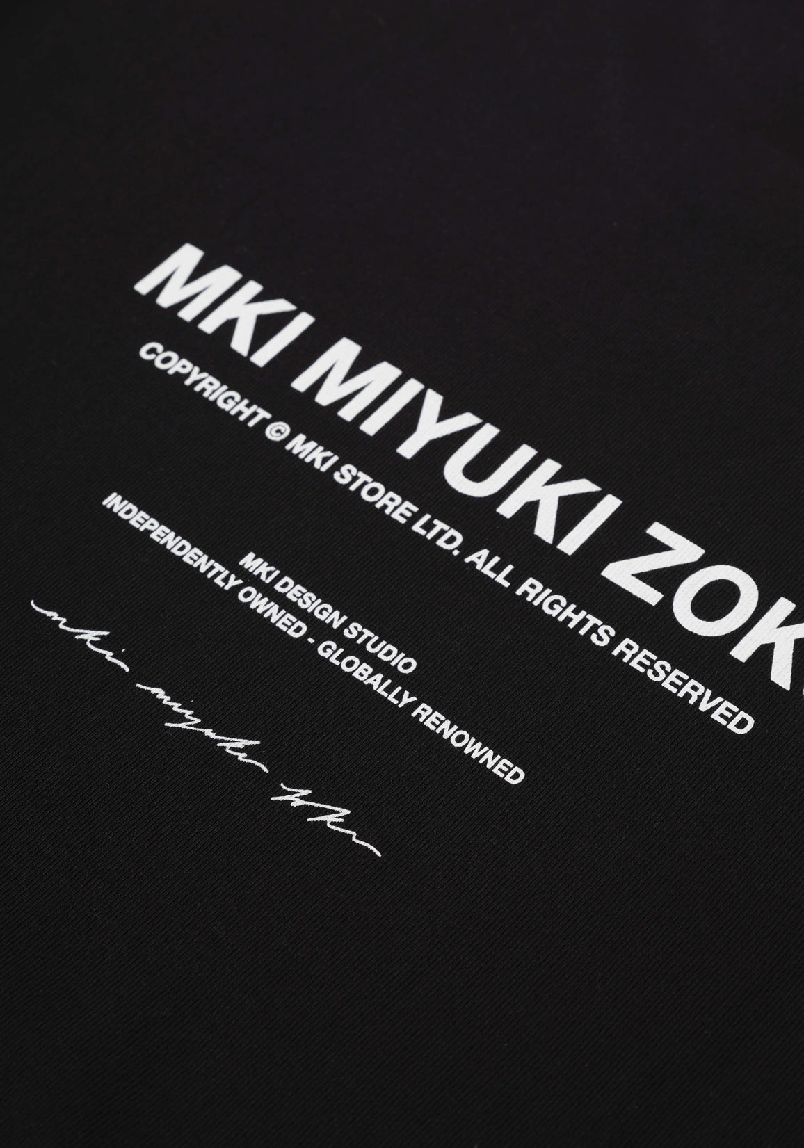 Flat close-up of the printed rear branding on the Design Studio Crewneck in Black
