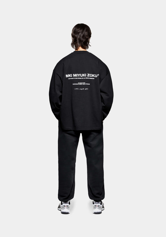 Full back view of the MKI Design Studio long sleeve oversized t-shirt in a black colour in a boxy fit