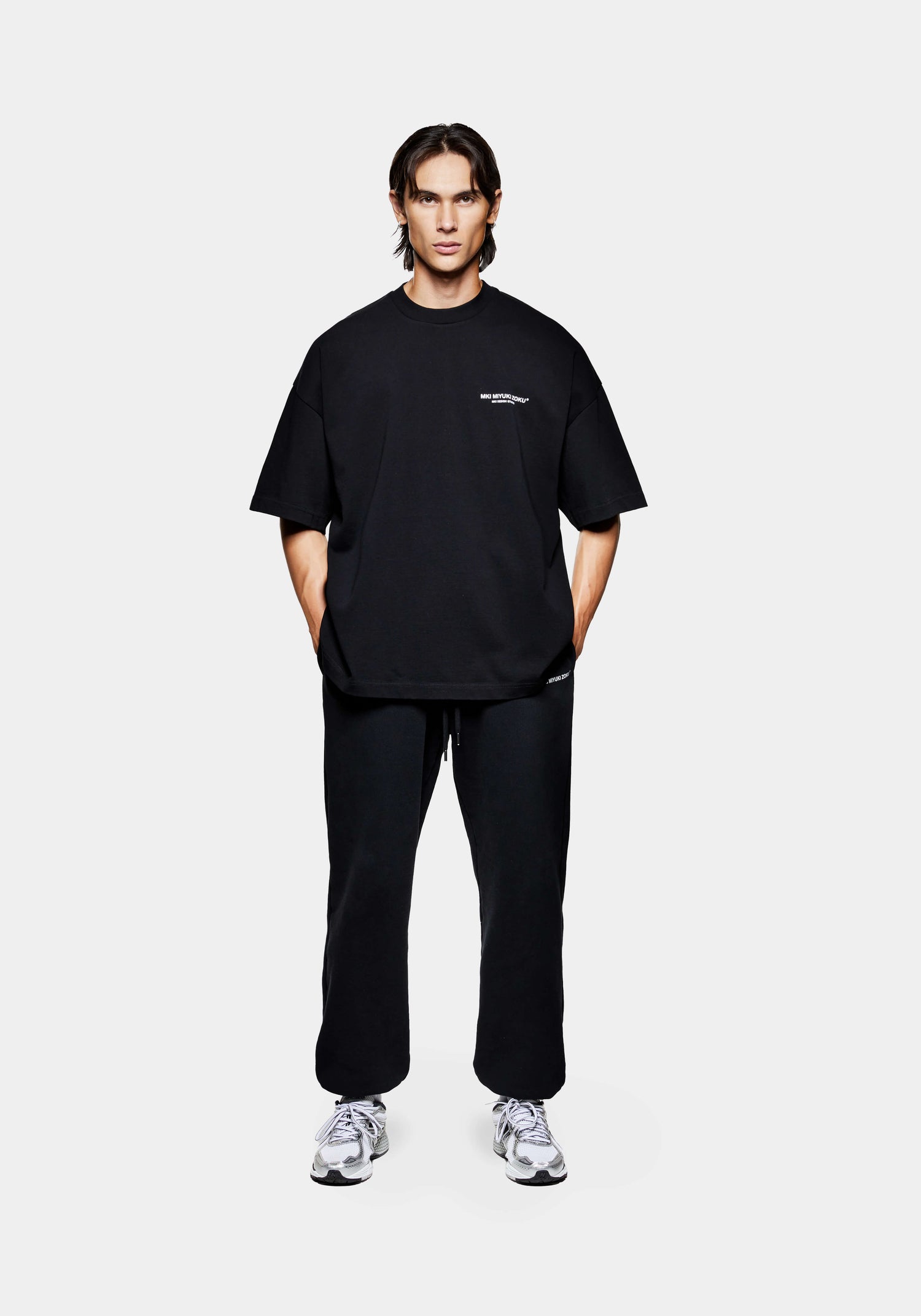 Front view of the men's MKI Design Studio T-Shirt in Black styled with the MKI Uniform Joggers

